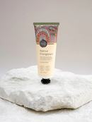 A tube of "Koh" Native Frangipani hand cream with macadamia seed oil is displayed on a white rock.
